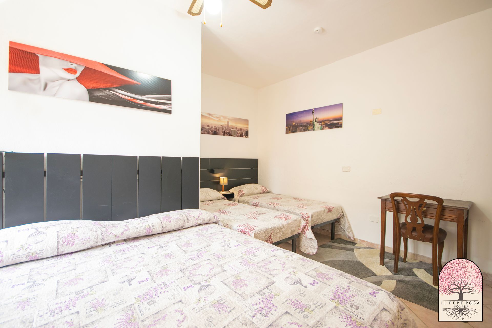 Una camera da letto con tre letti, una scrivania e una sedia.