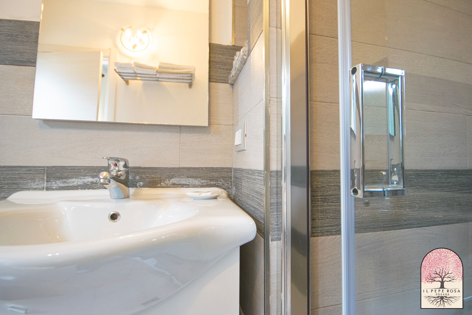 Un bagno con lavandino, specchio e doccia.