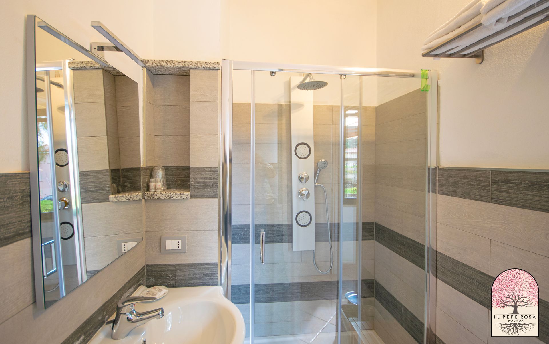 Un bagno con lavandino, specchio e box doccia.