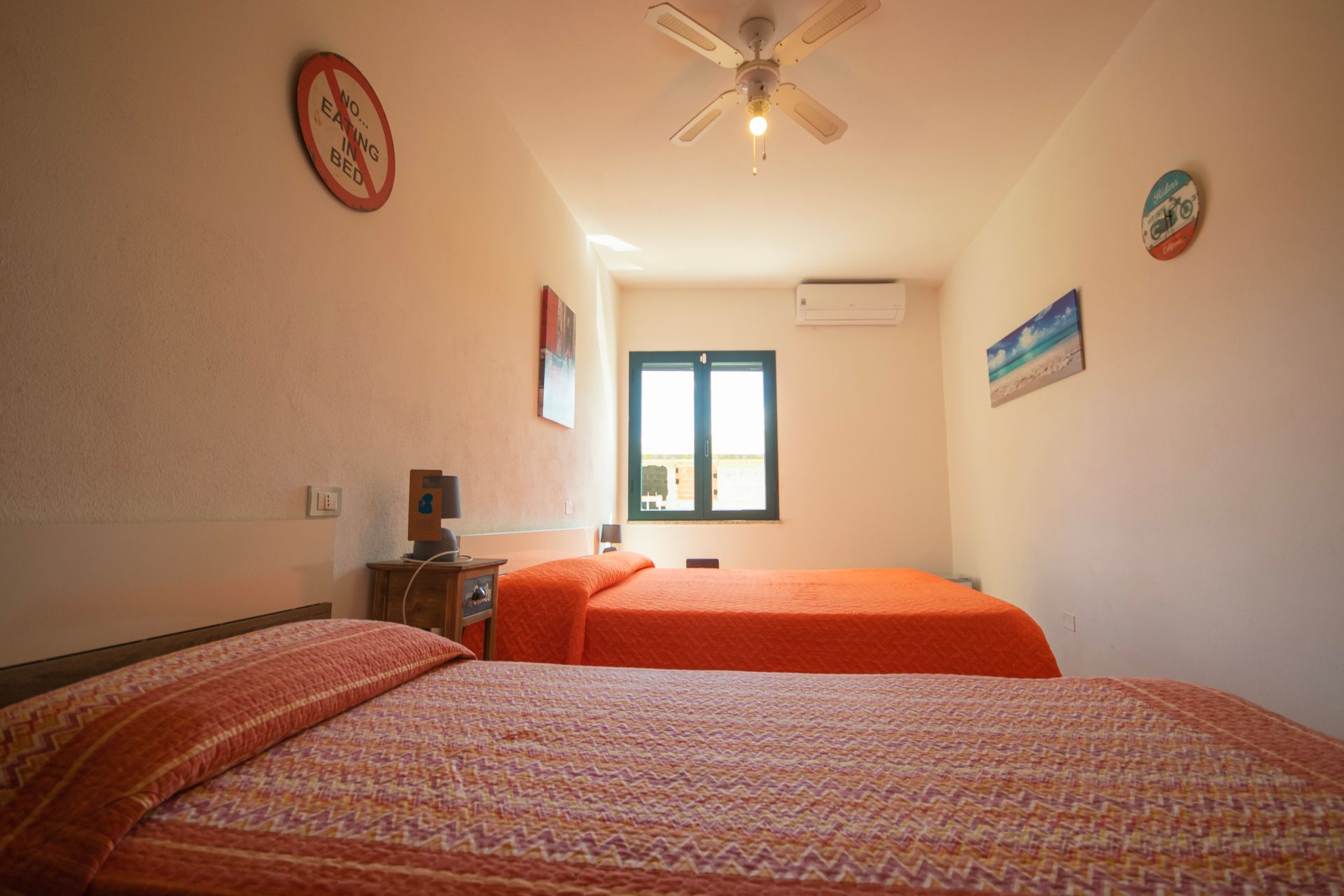 Una camera da letto con due letti e un ventilatore a soffitto.