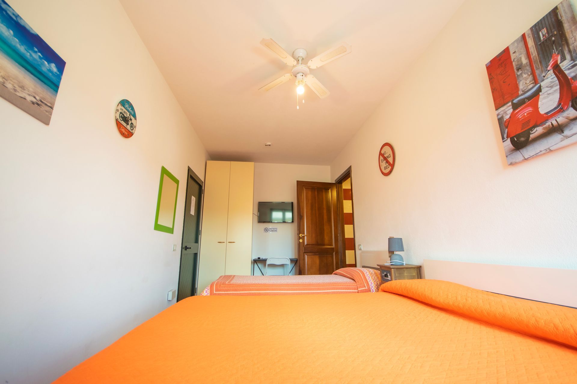 Una camera da letto con due letti e un ventilatore a soffitto