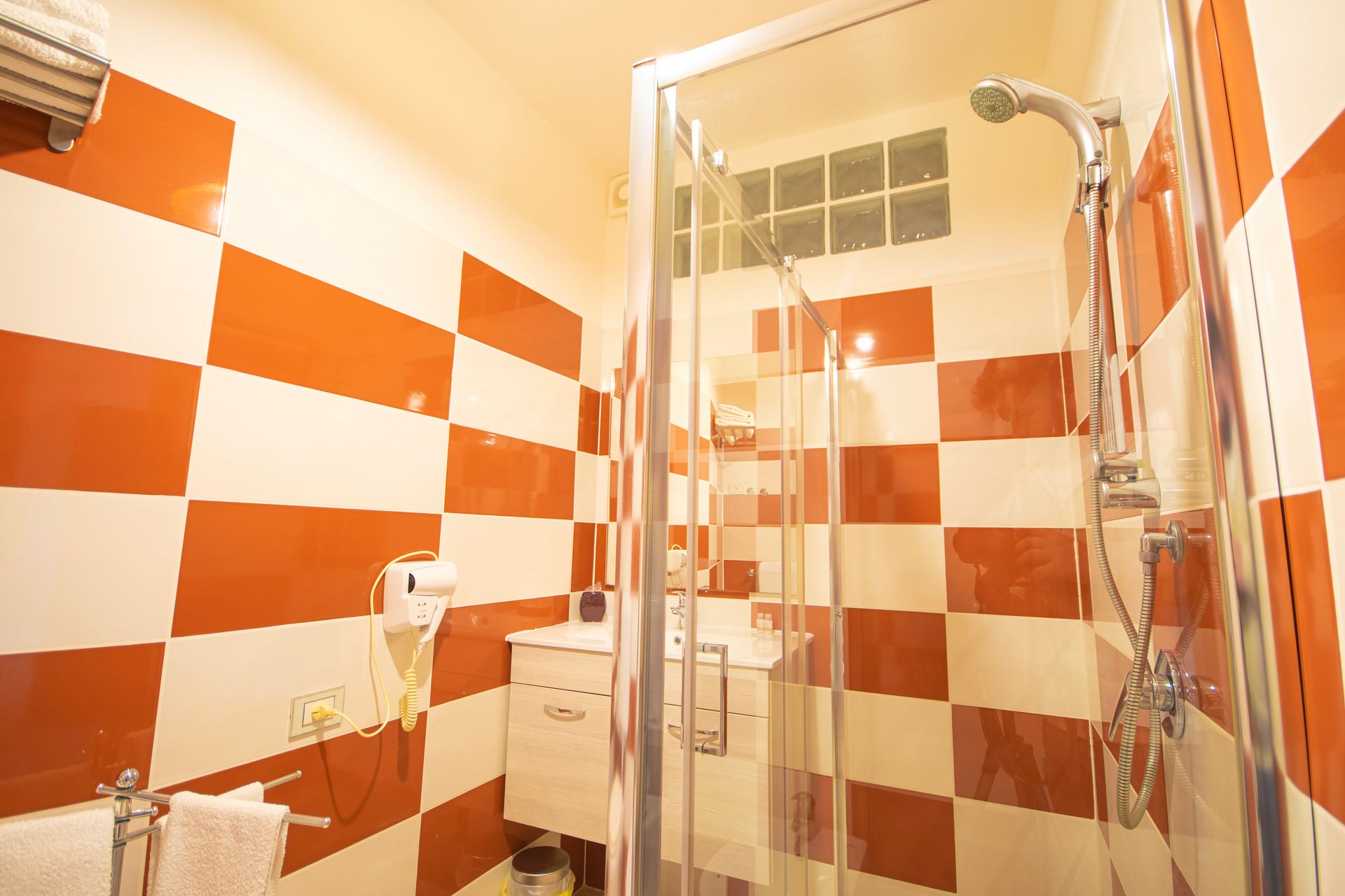 Un bagno con piastrelle rosse e bianche e una cabina doccia