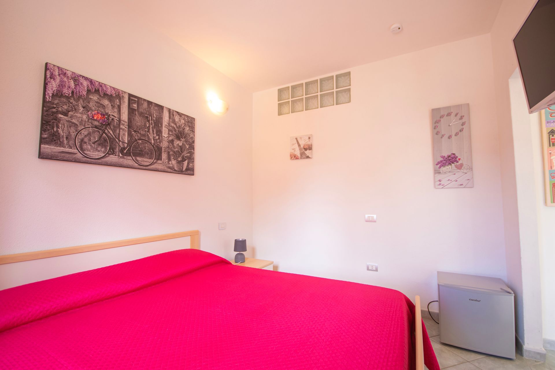 Una camera da letto con un letto e un orologio sul muro.