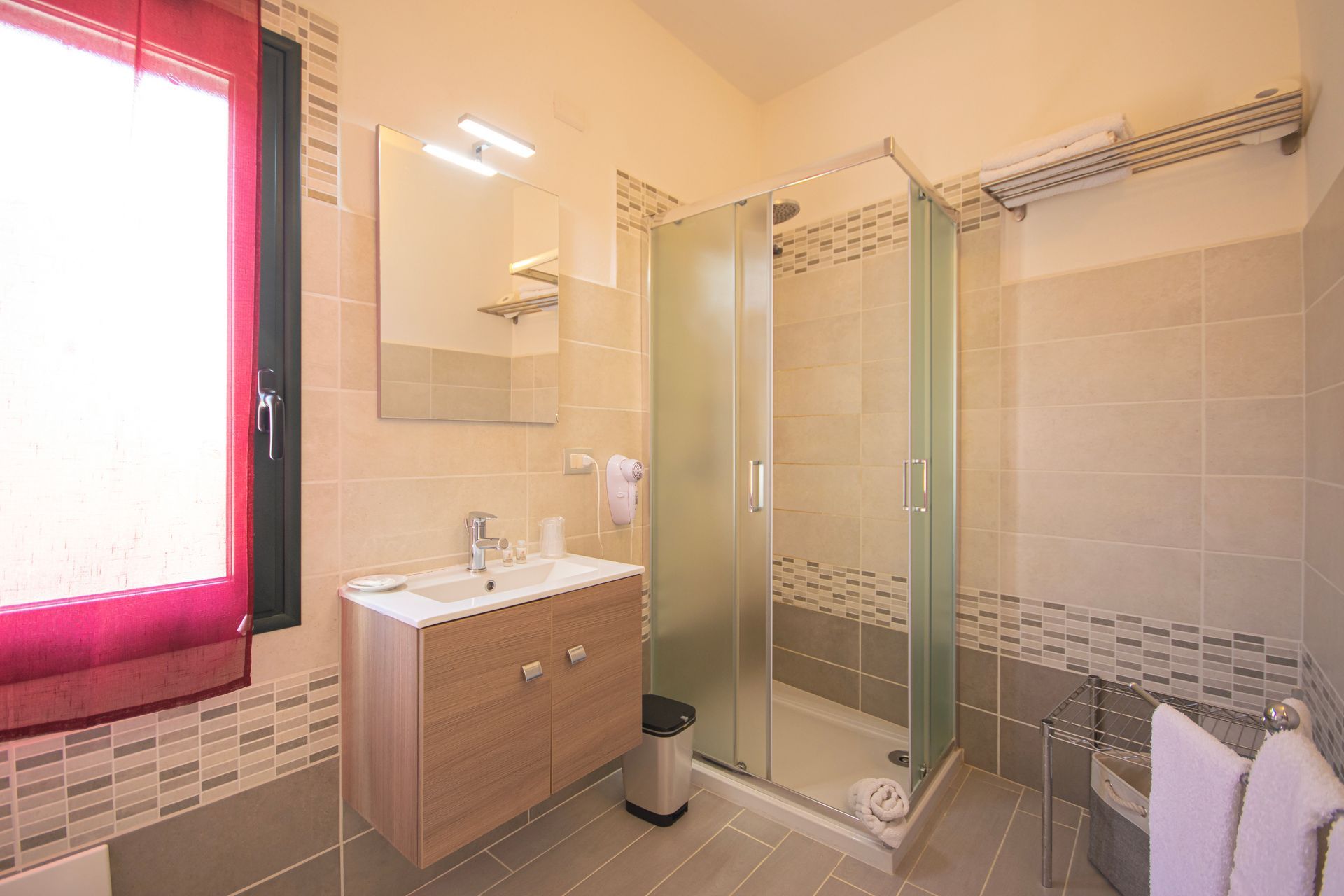 Un bagno con lavandino, specchio e box doccia.