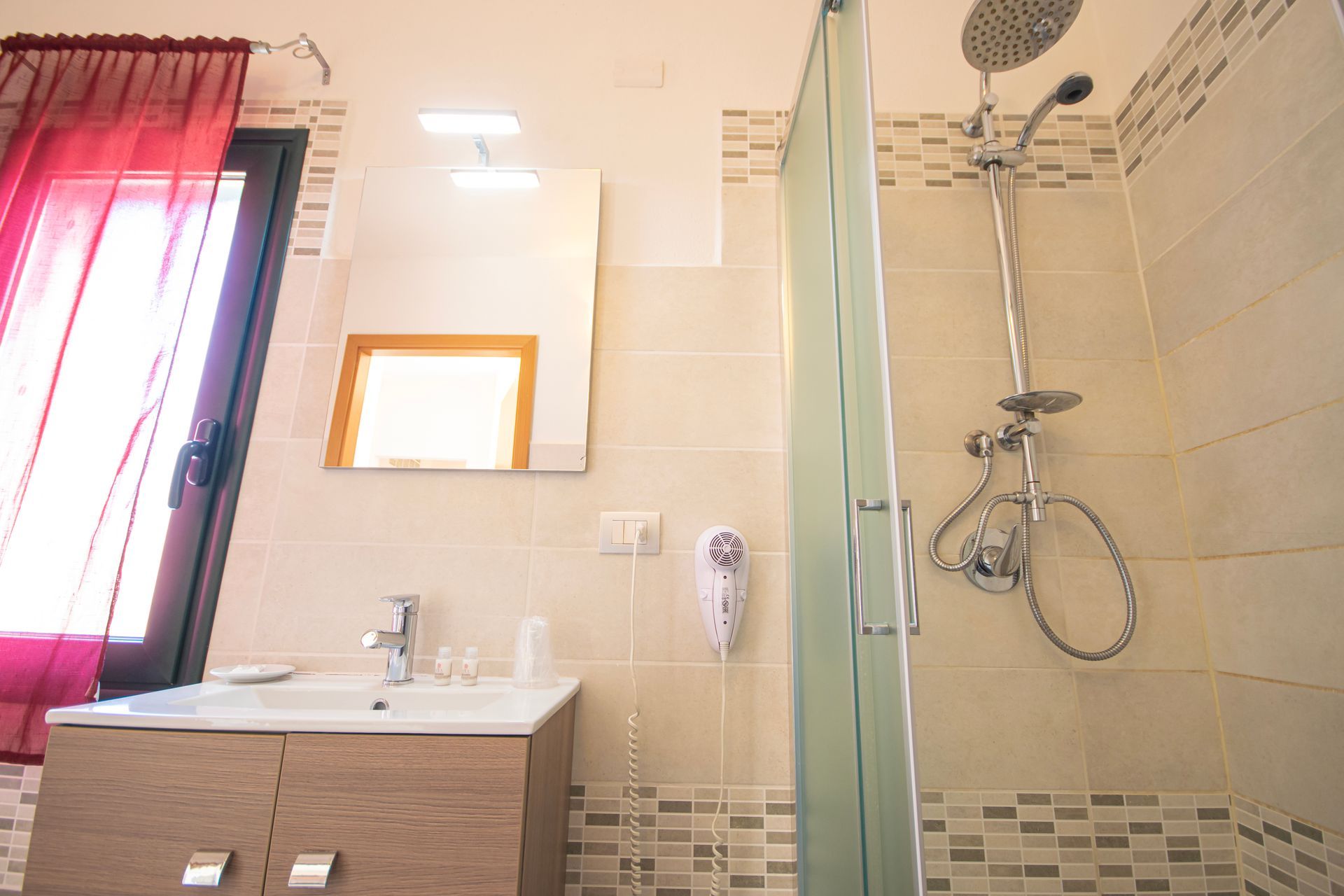 Un bagno con lavandino, specchio e doccia.