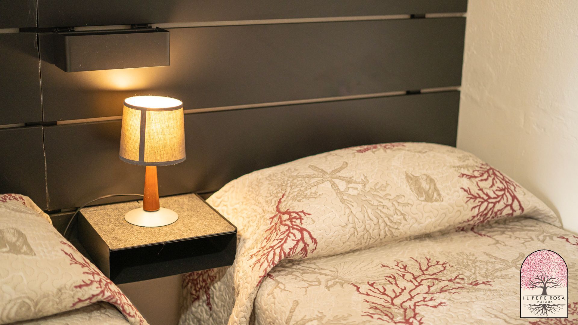 Una camera da letto con due letti e una lampada sul comodino