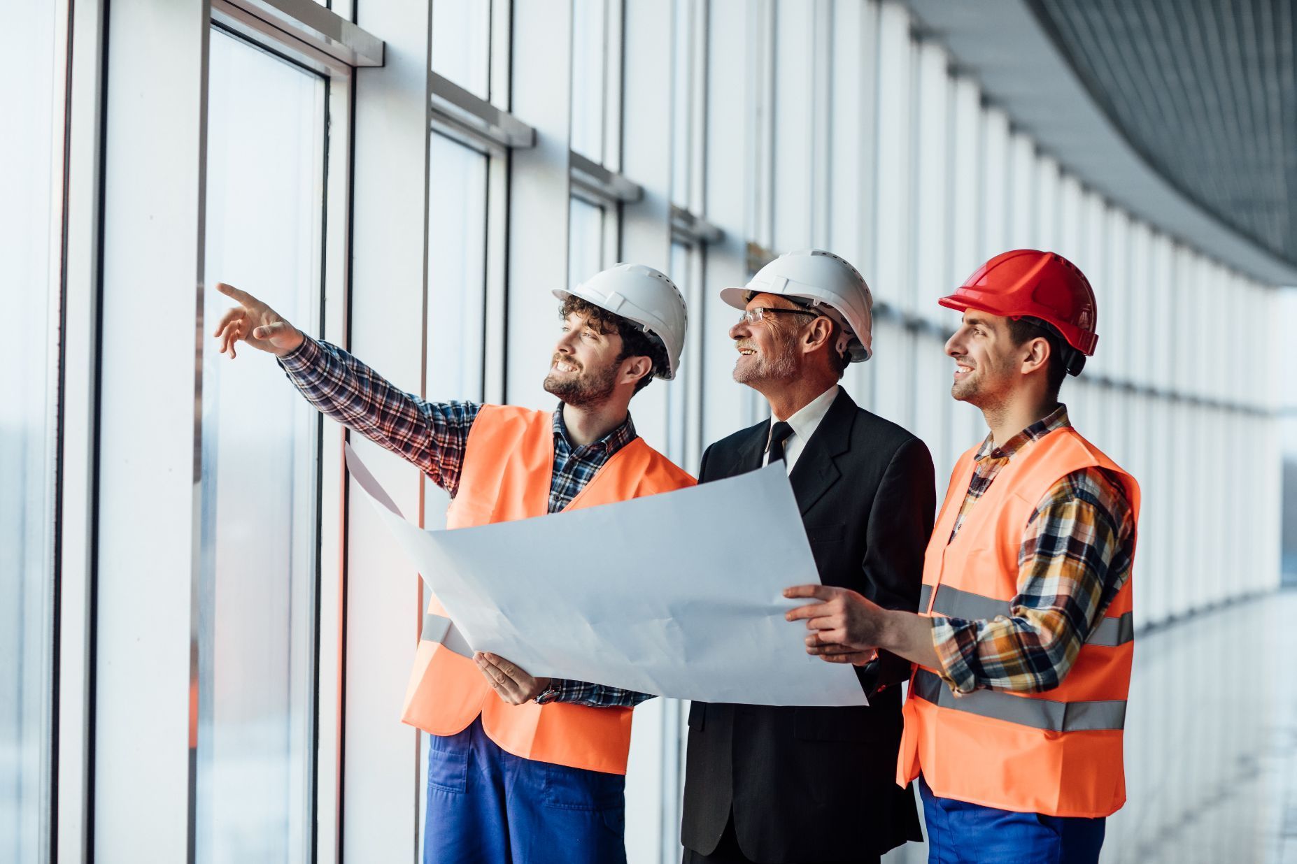 A group of construction workers are looking out of a window.