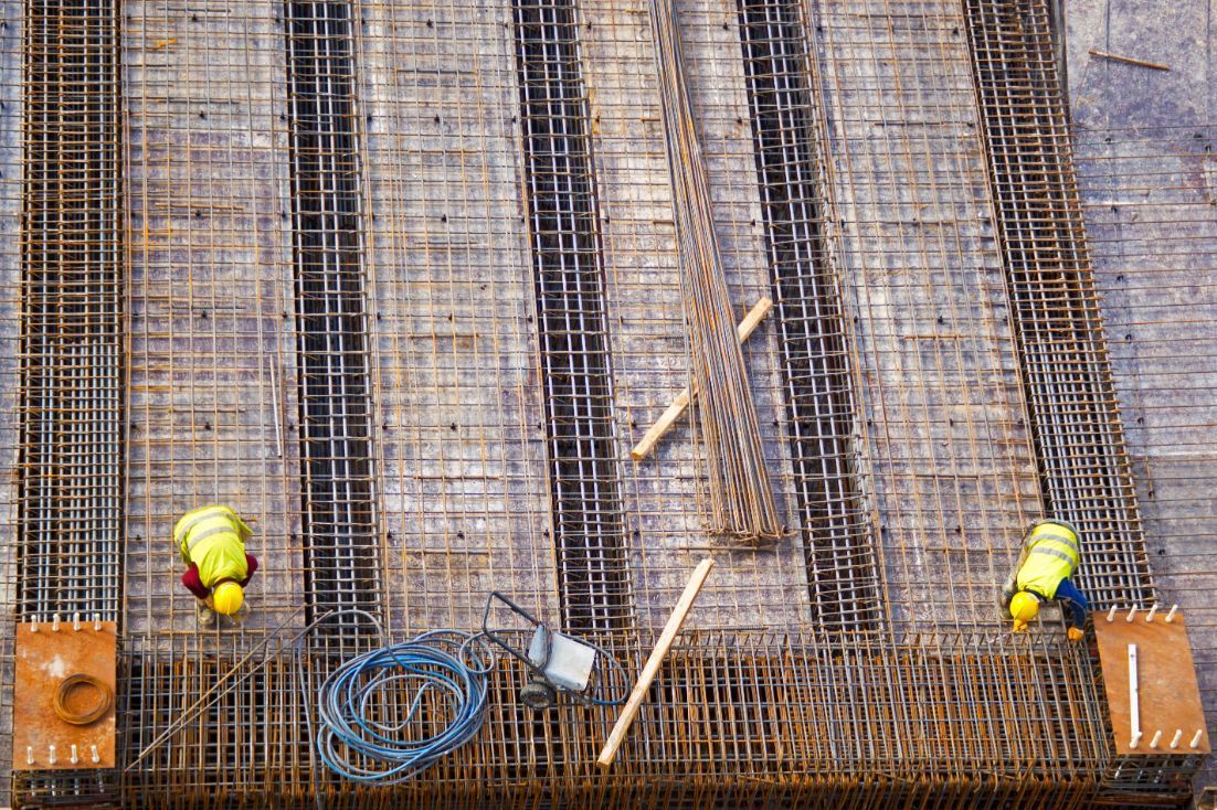 A group of construction workers are working on a steel structure.