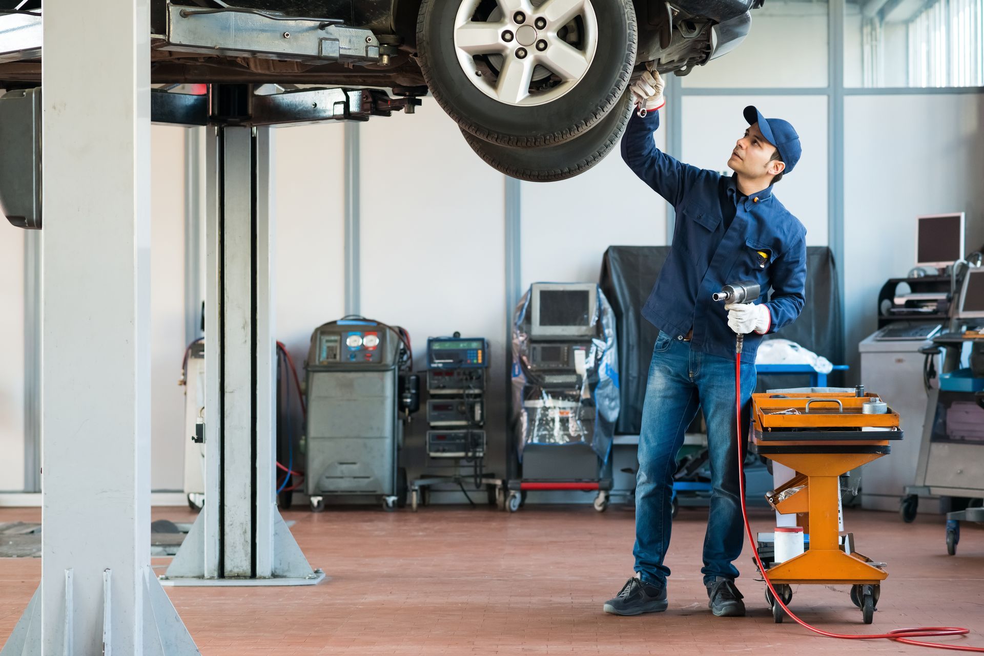 A man is working on a car in a garage.