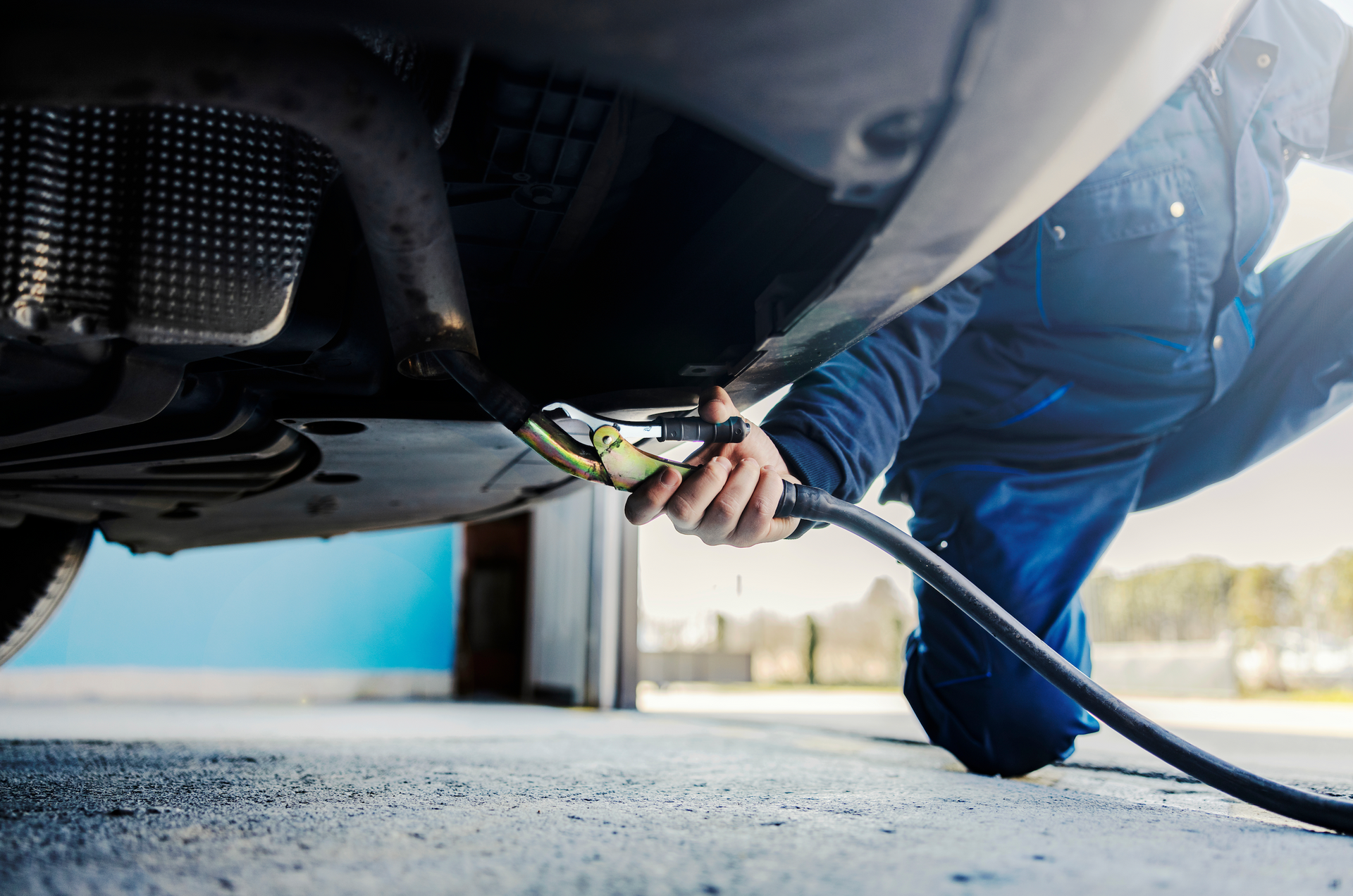A man is pumping gas into a car with a hose.