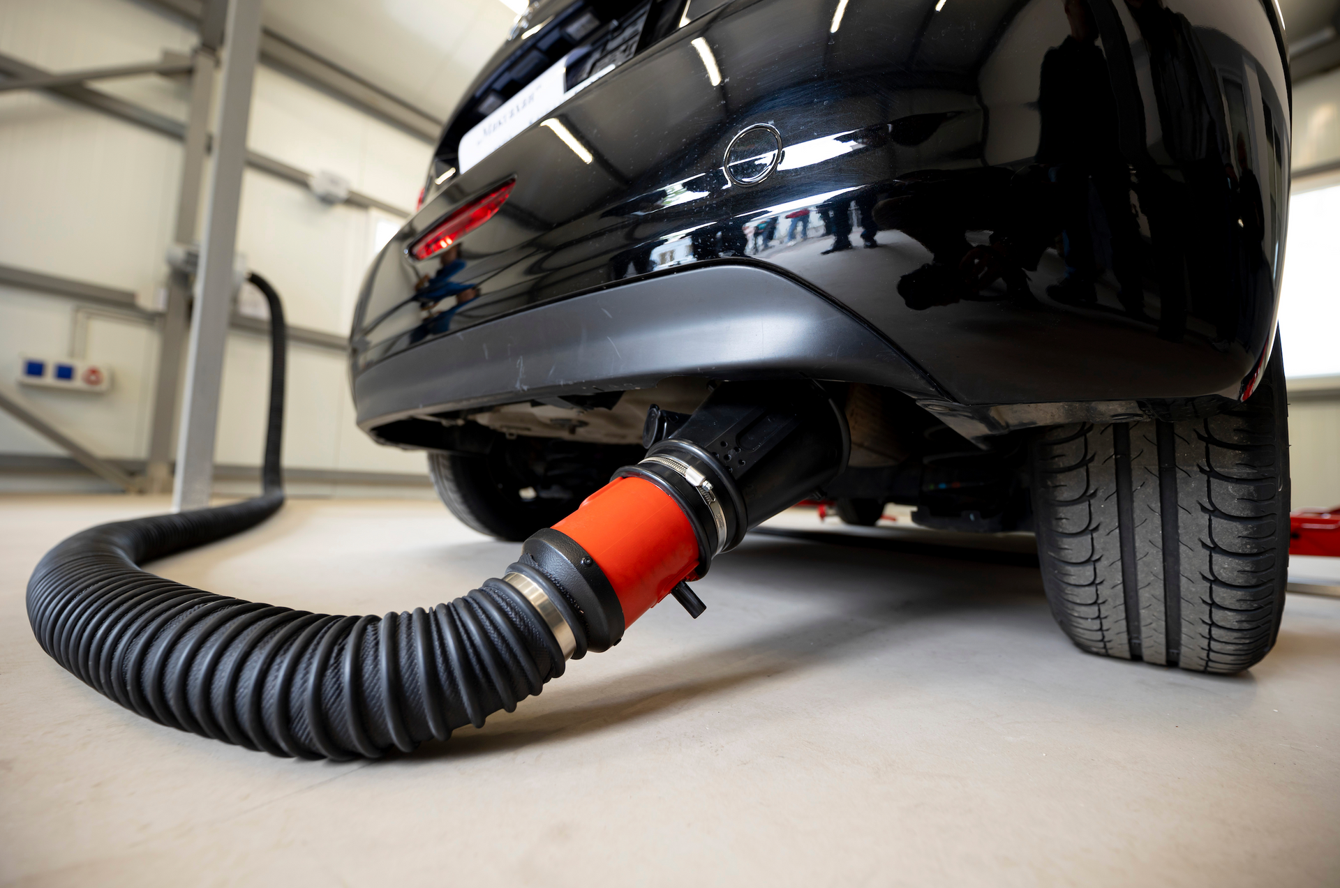 A close up of a car with a hose attached to it.