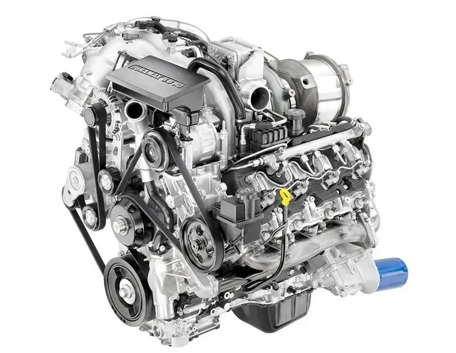 Silver and black diesel engine with belts, pulleys, and a turbocharger.