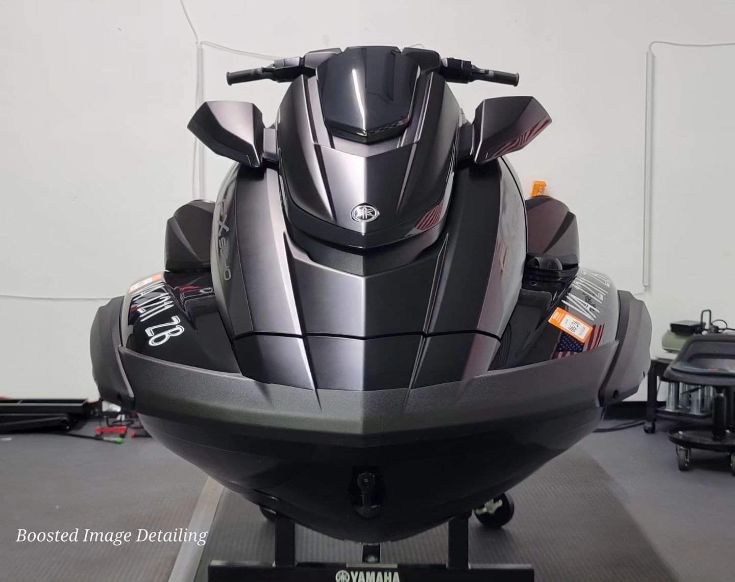 A black jet ski is sitting on a stand in a room.
