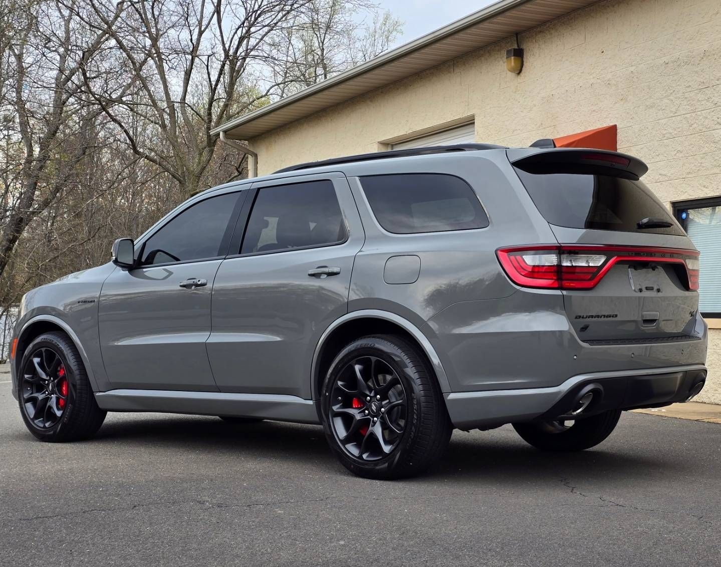 A gray durango is parked in front of a building.