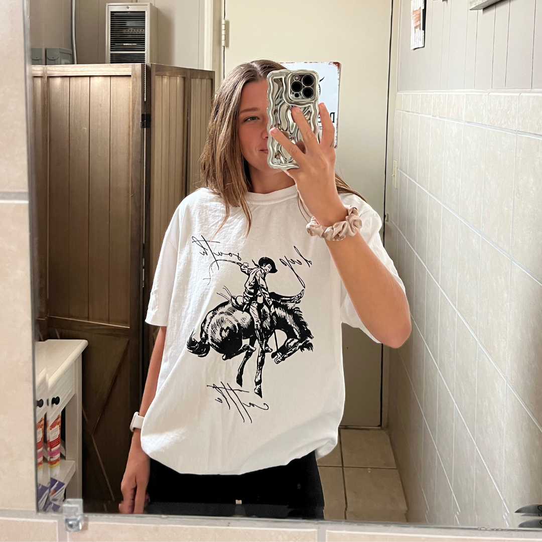 A white t-shirt with a man riding a horse on it