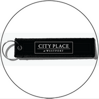 A black keychain with the city place westport logo on it.