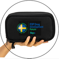 A person is holding a black bag that says fop drug development forum