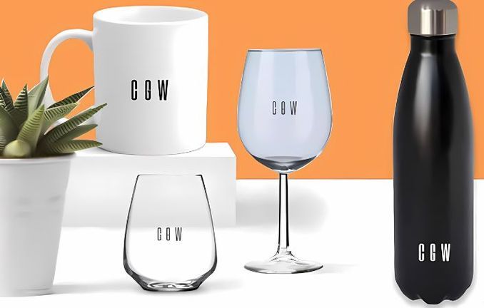 A mug a wine glass a water bottle and a potted plant with cow written on them