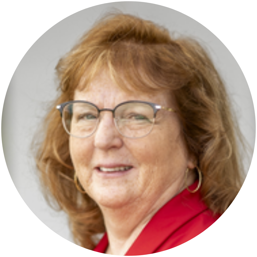 A woman wearing glasses and a red shirt smiles for the camera