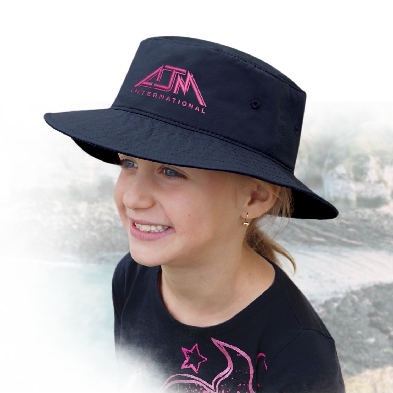 A little girl wearing a black hat that says aim international