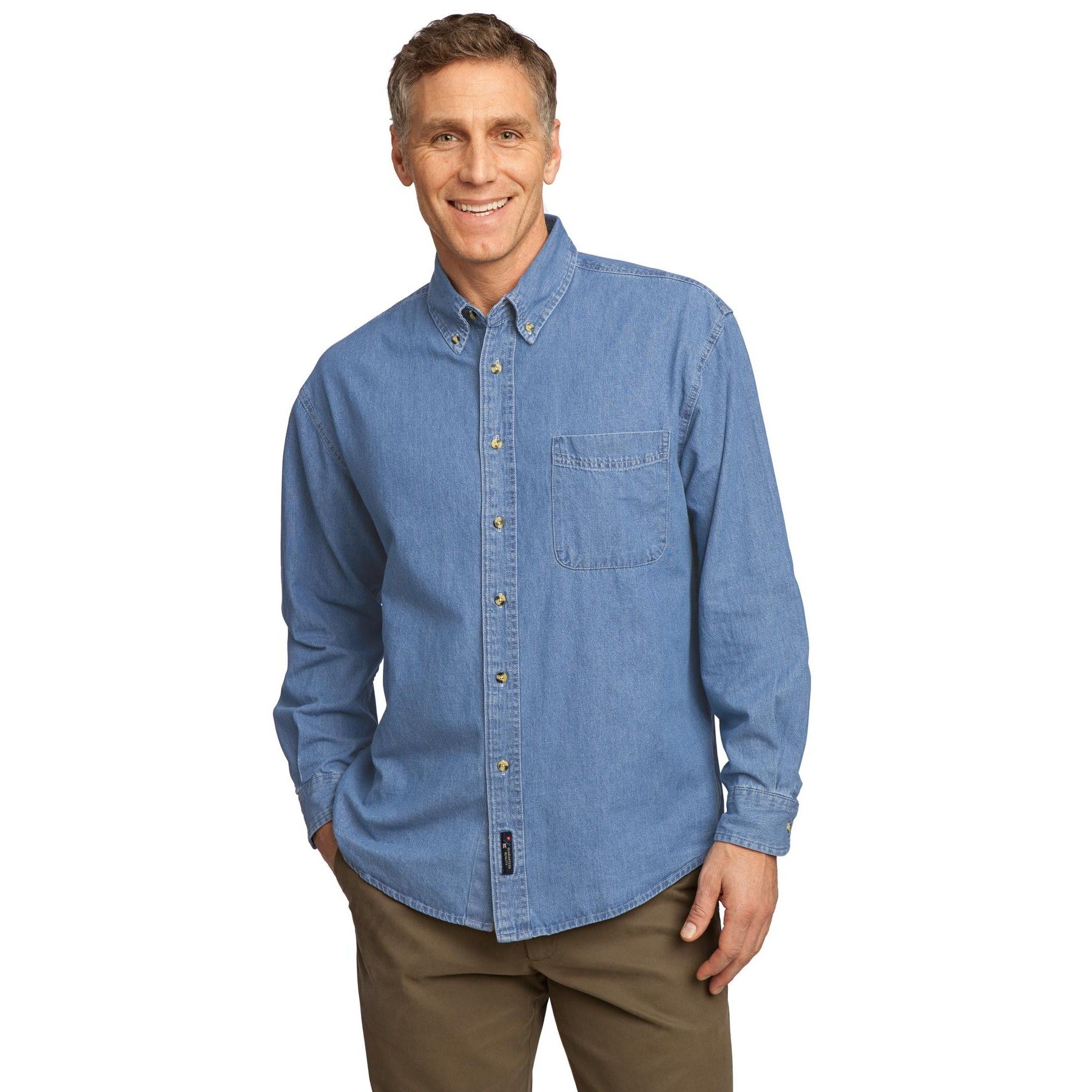 A man wearing a light blue denim shirt and khaki pants