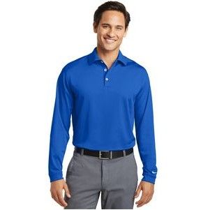 A man is wearing a blue long sleeve polo shirt and grey pants.