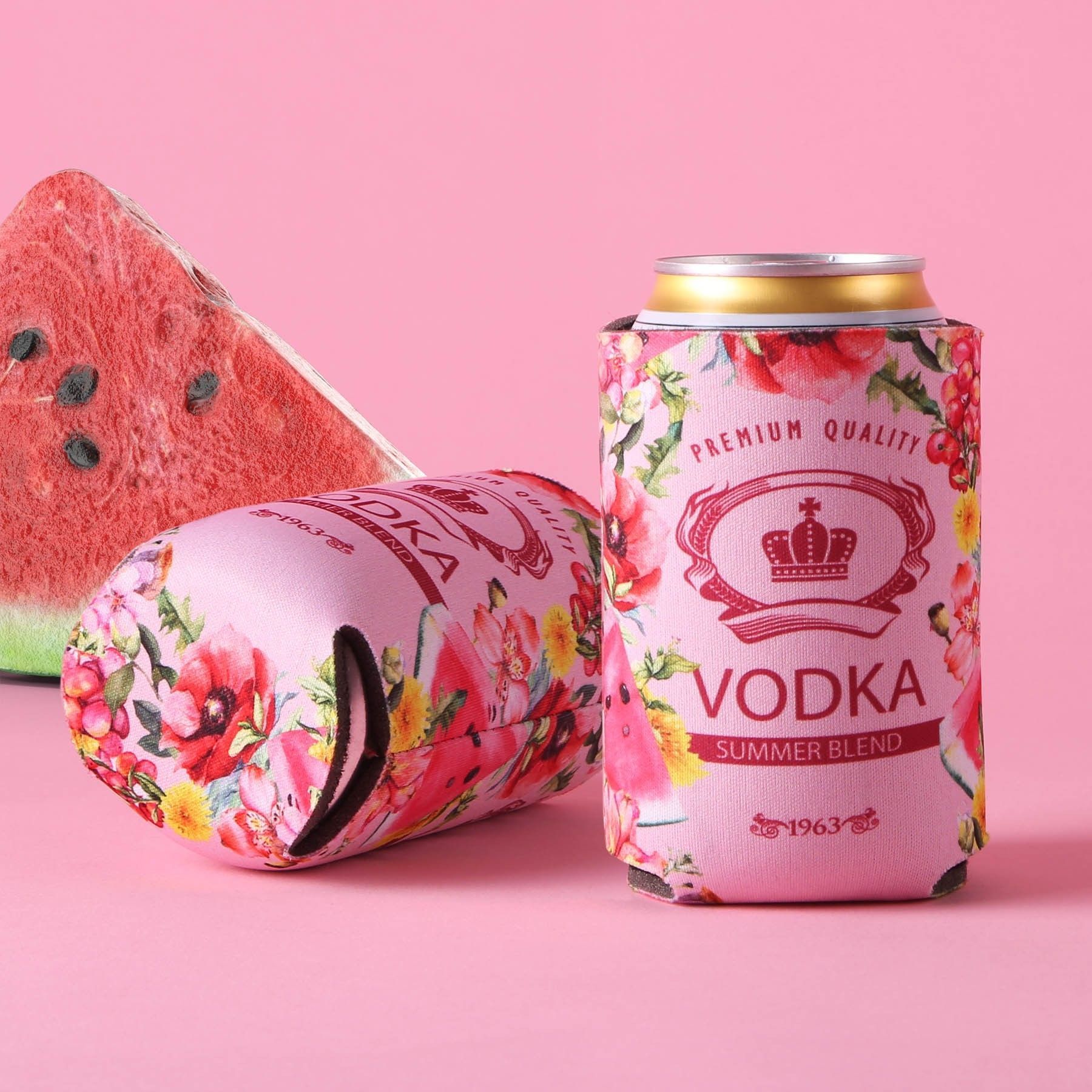 A can of vodka is sitting on a pink table next to a slice of watermelon.