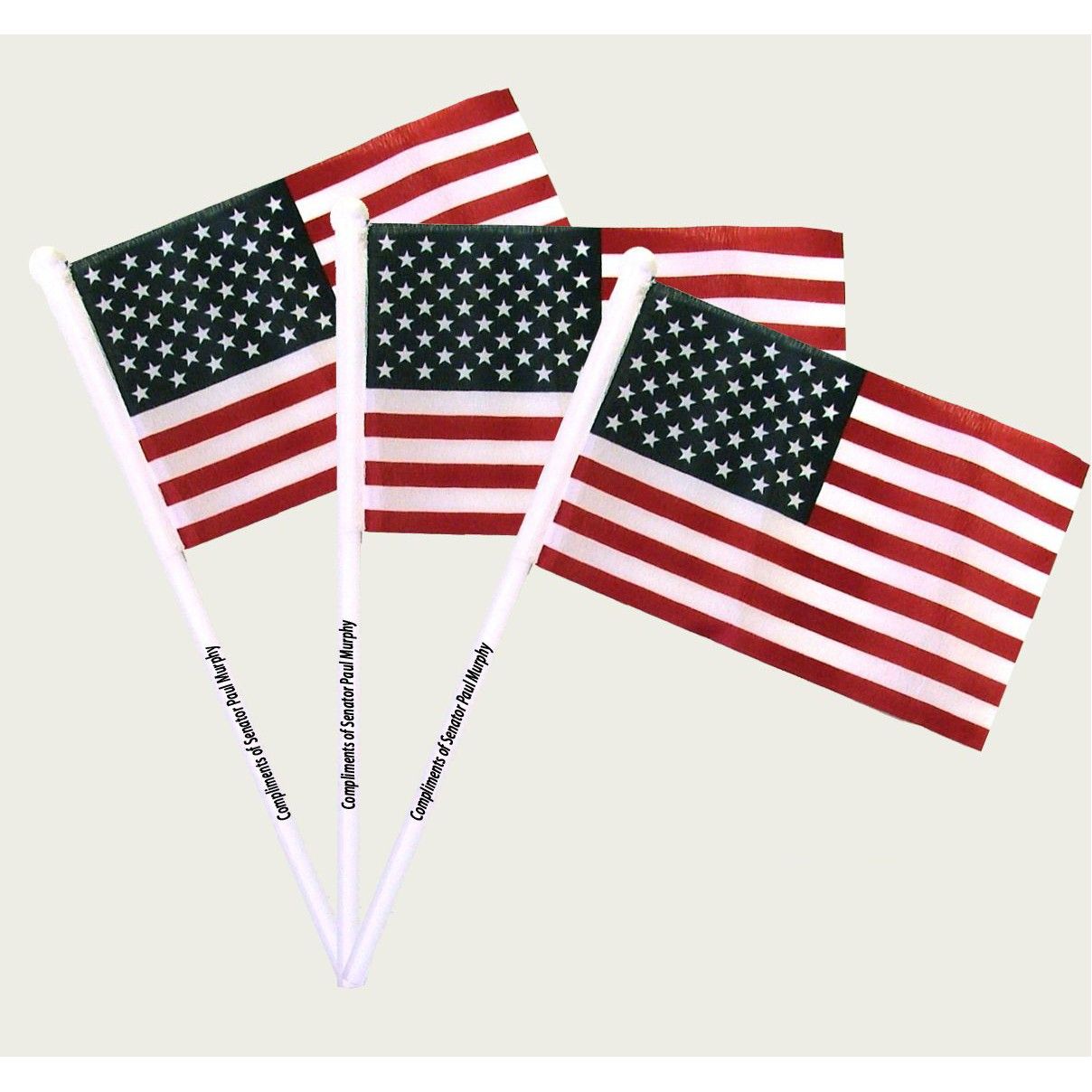 Three small american flags on white sticks on a white background