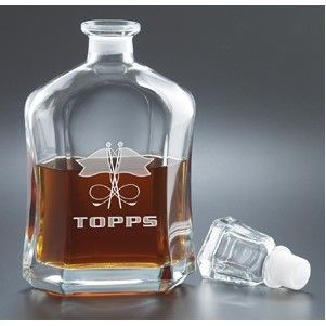 A clear glass decanter with the name topps on it.