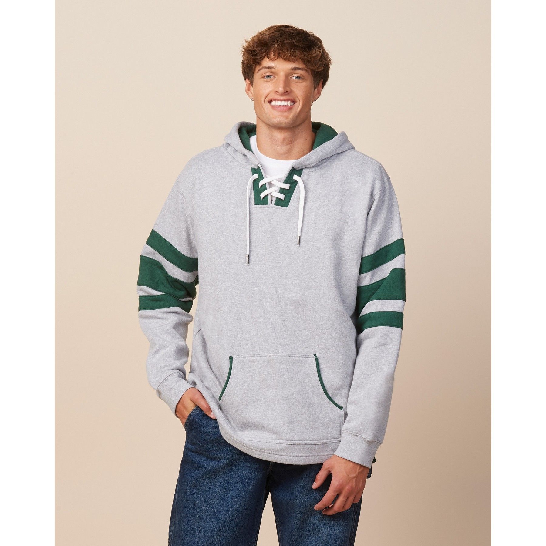 A man wearing a grey hoodie with green stripes on the sleeves