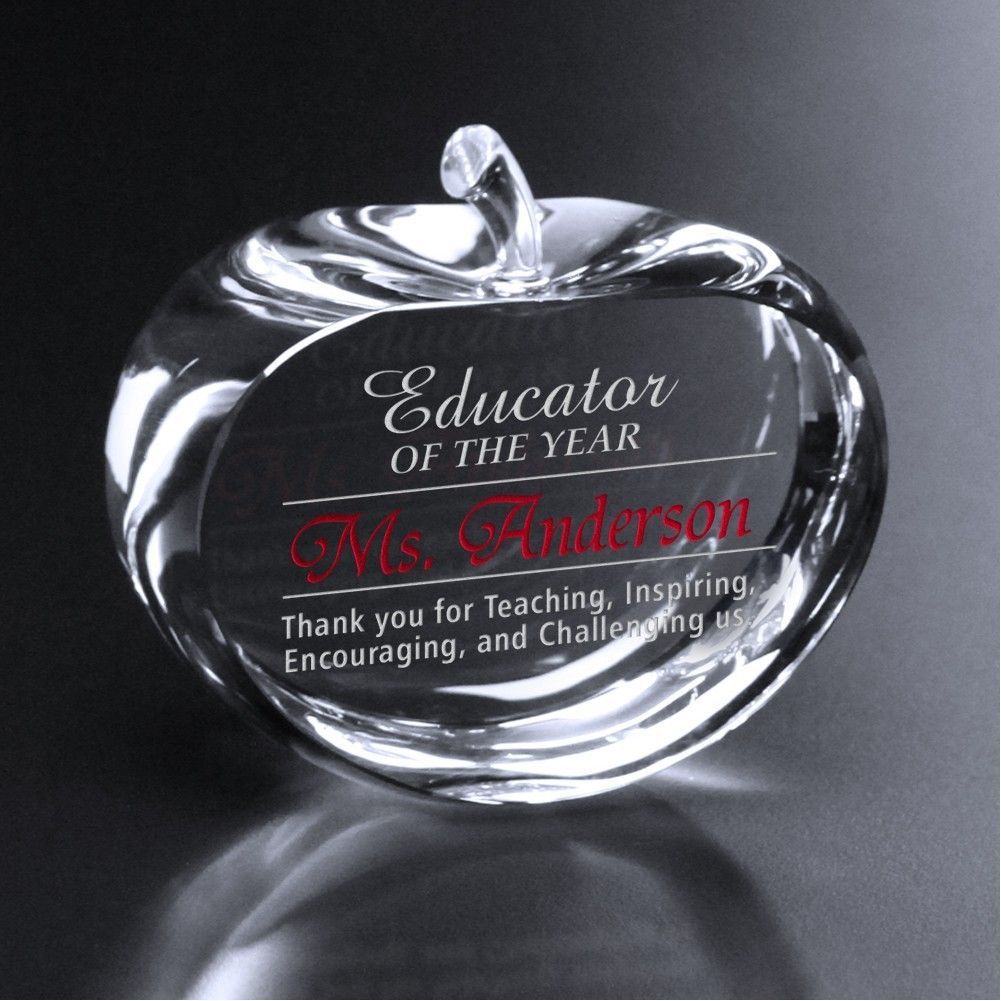 A glass apple that says ' educator of the year ' on it