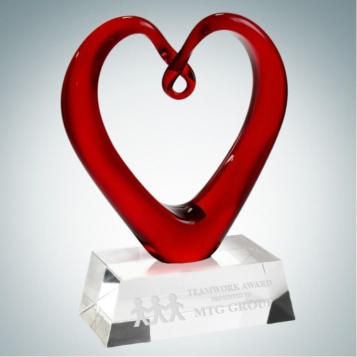 A red glass heart on a clear base that says teamwork award
