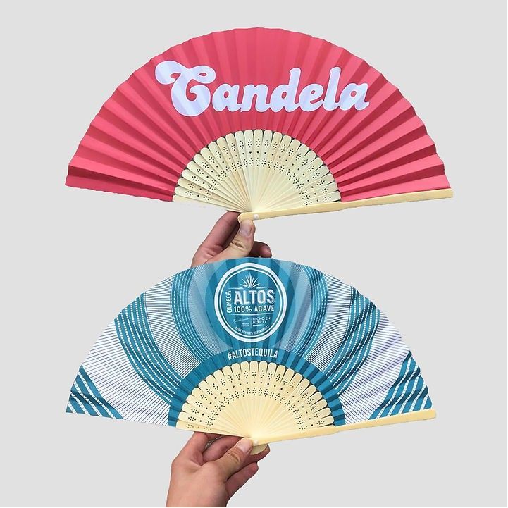 A person is holding a fan with the name candela on it