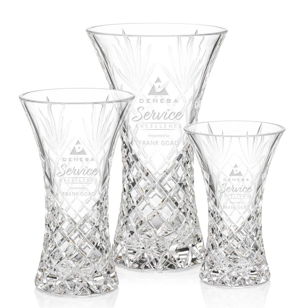 Three clear glass vases are sitting next to each other on a white surface.