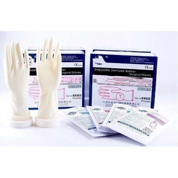 A pair of latex gloves are sitting next to a box of gloves.