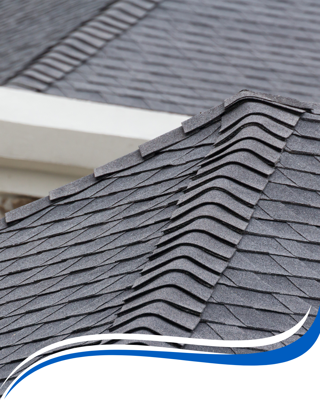 Gray asphalt shingle roof, close-up view showing overlapping shingles and the roof's ridge.