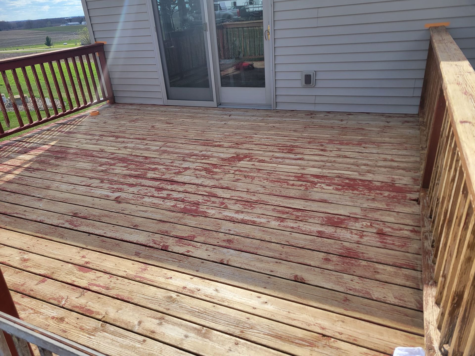 A Wooden Deck With A Sliding Glass Door And A Railing – Cottage Grove, MN - Minnesota Nice Painting