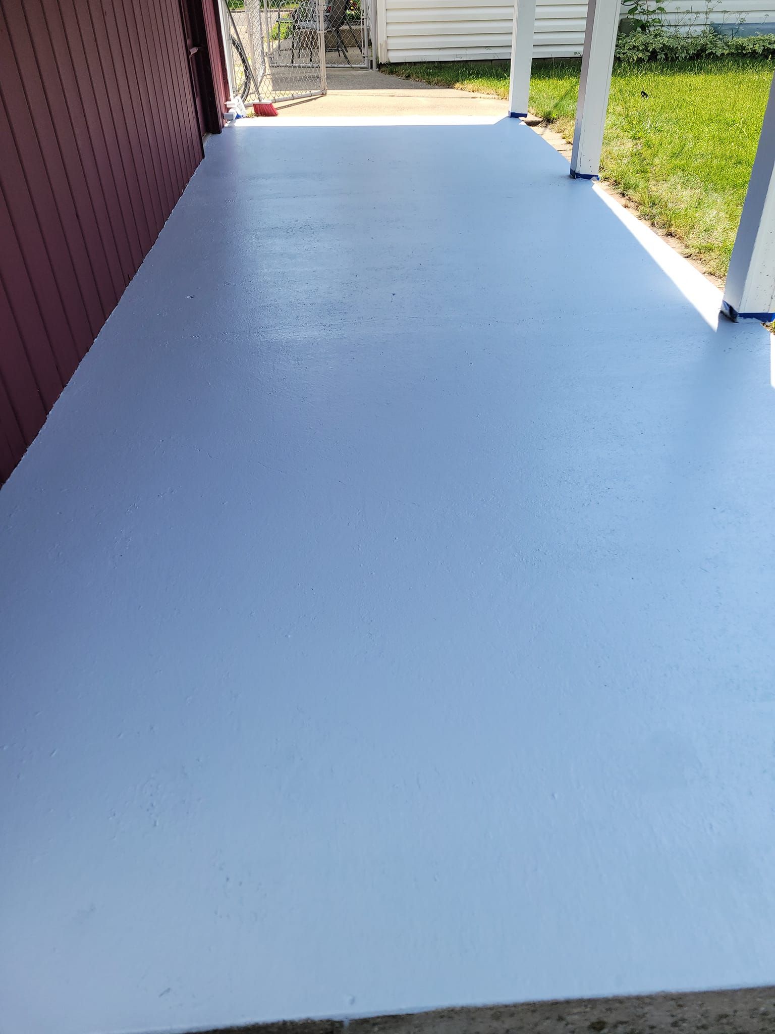 A Blue Concrete Porch With A Red Building In The Background – Cottage Grove, MN - Minnesota Nice Painting