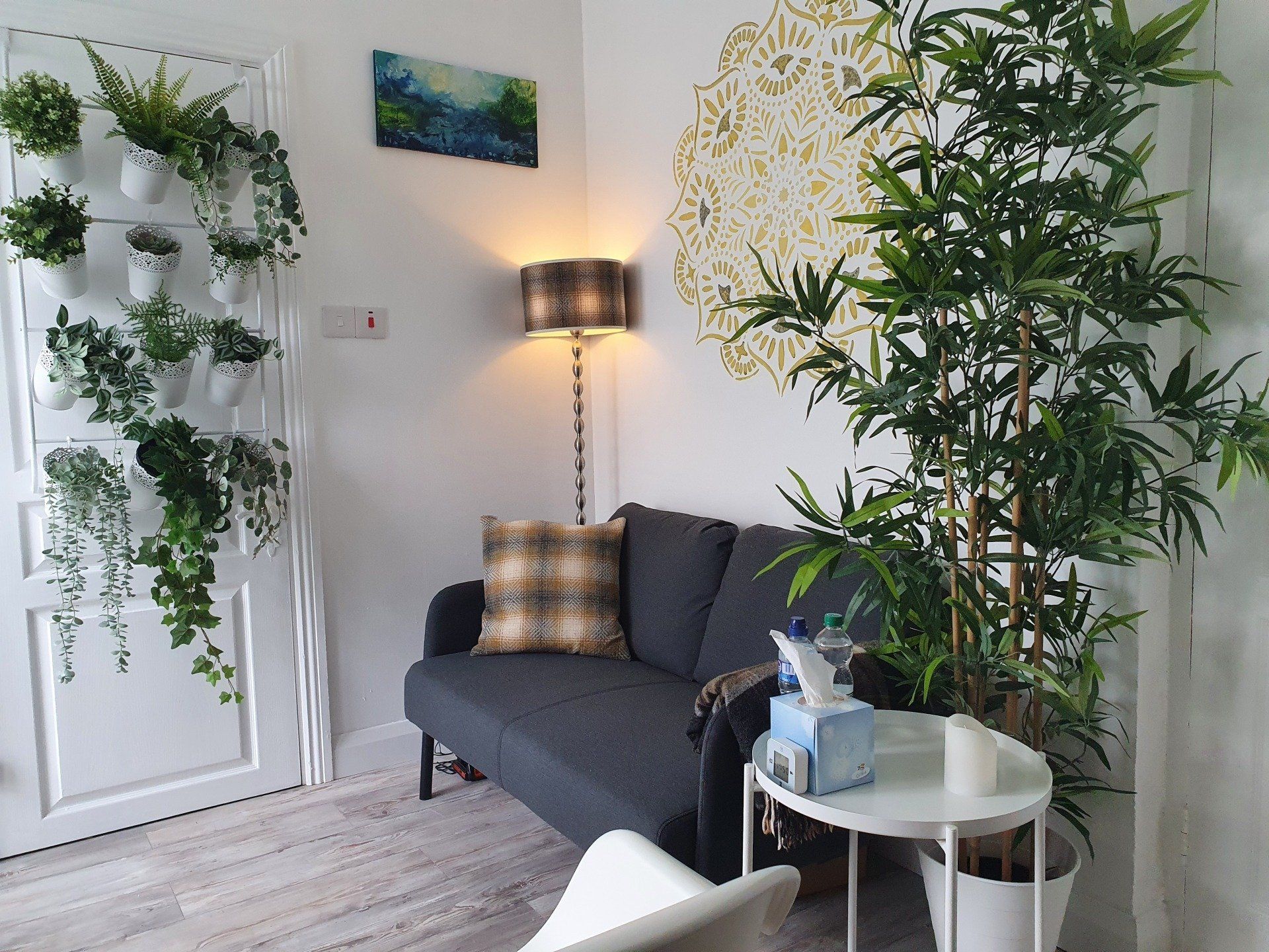 A living room with a couch , chair , table and potted plants.