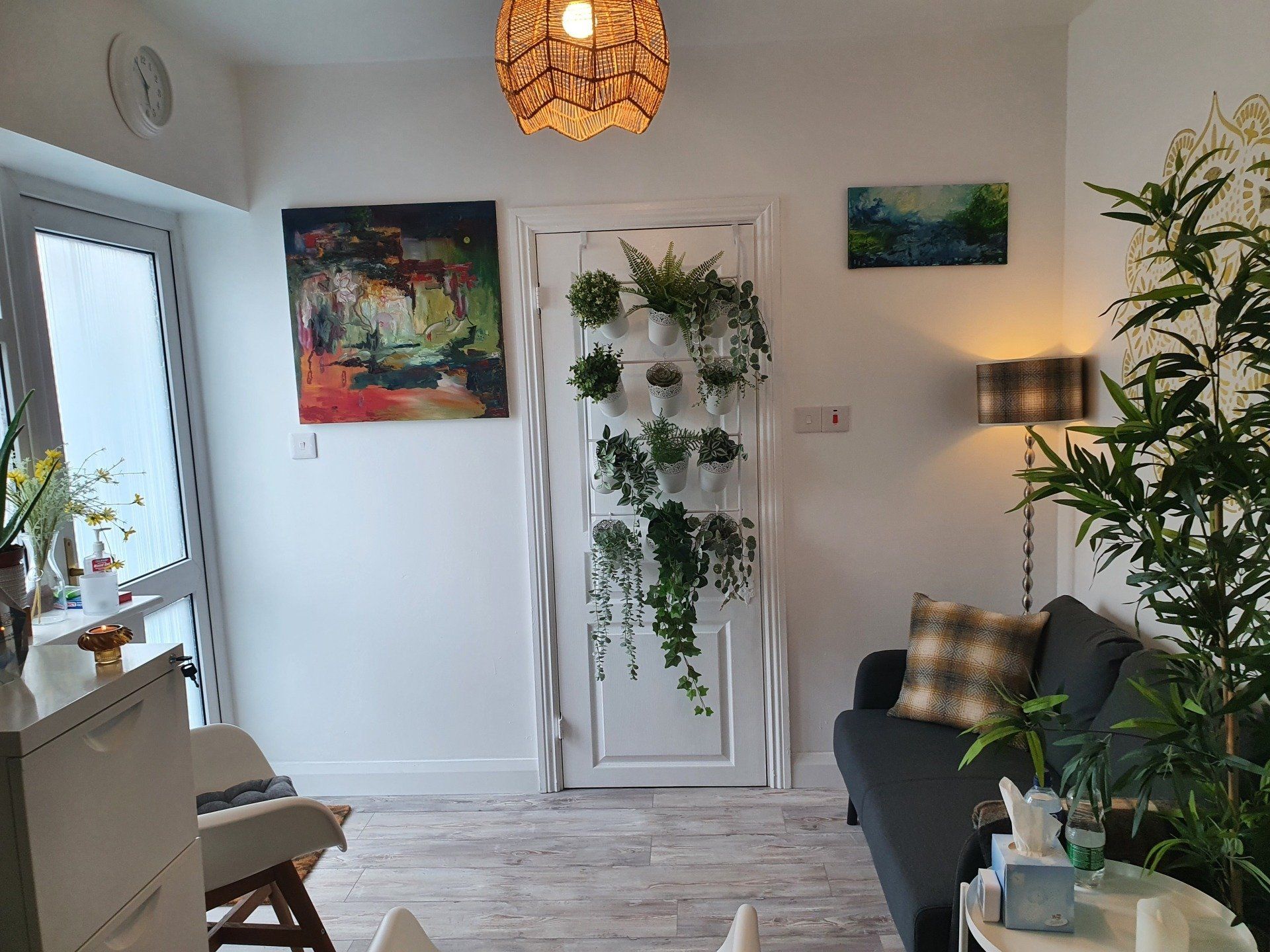A living room with a couch , chair , table and plants.
