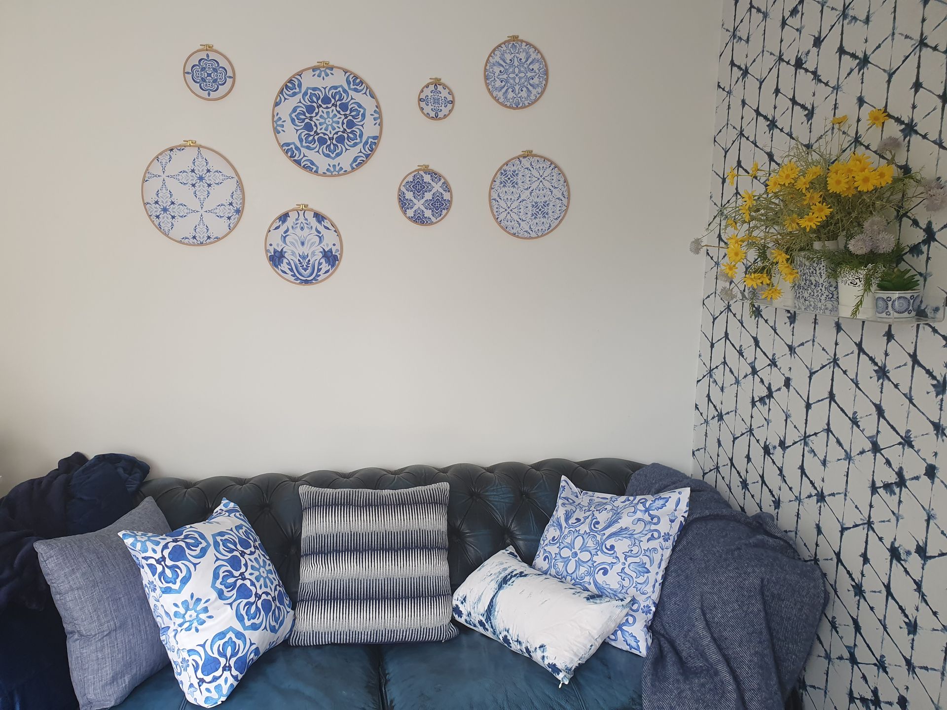 A living room with a blue couch and blue and white pillows
