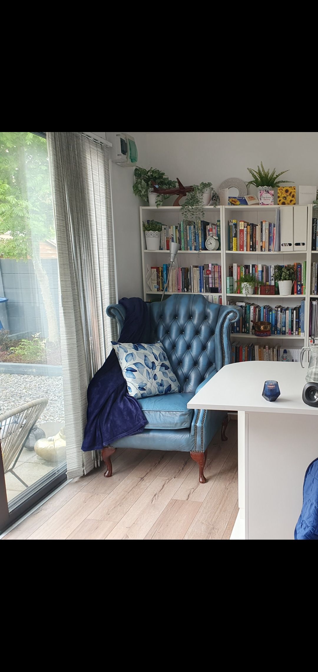 A blue chair is sitting in a room next to a window.