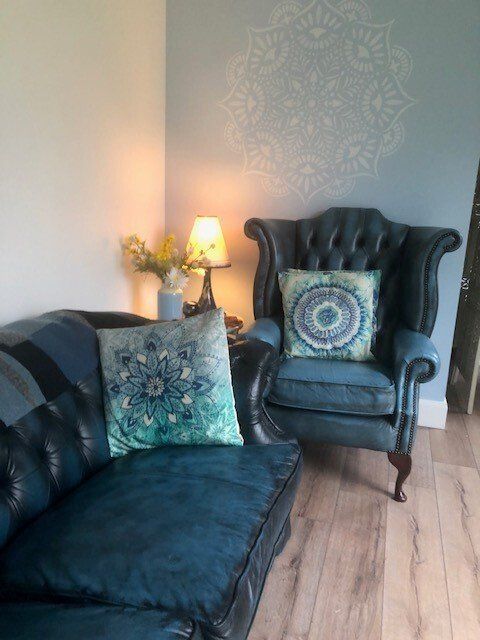 A living room with a couch , chair and lamp