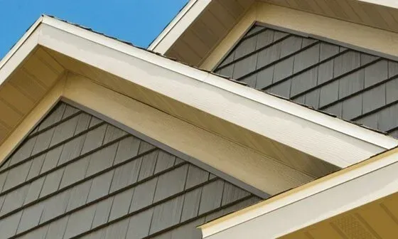 White rain gutter system on a roof, with a downspout.
