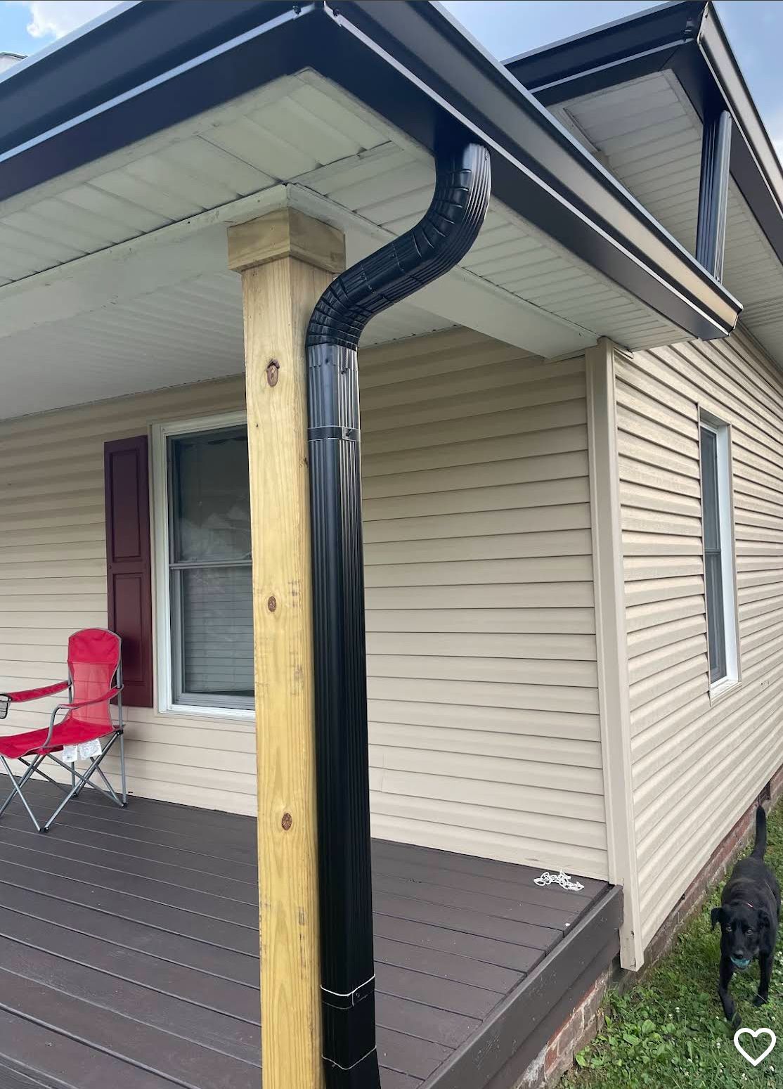 Beige stucco house exterior with gutters and windows against a partly cloudy sky.