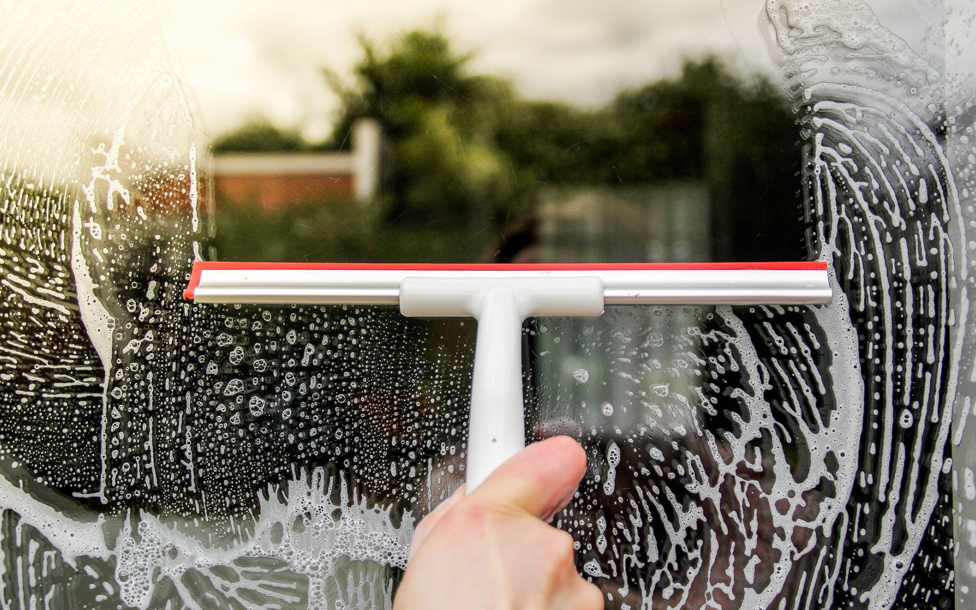 A person is cleaning a window with a squeegee.