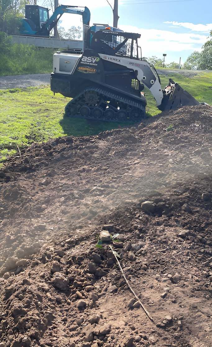 A Bulldozer is Moving Dirt in a Field — Campbell's Truck and Bobcat and Landscape Supplies In Gympie, QLD