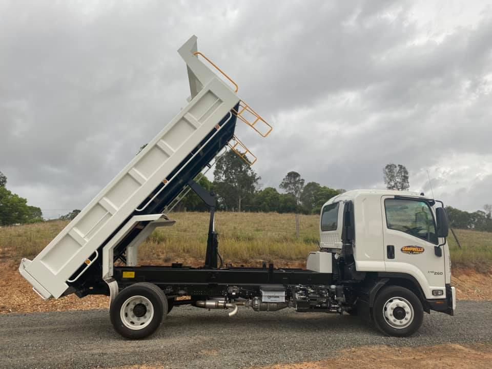 A Truck is Parked in a Yard With a Digger on the Back— Campbell's Truck and Bobcat and Landscape Supplies In Gympie, QLD