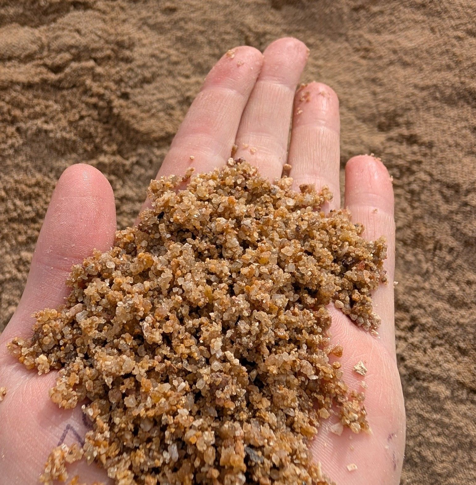 A person is holding a pile of sand in their hand.