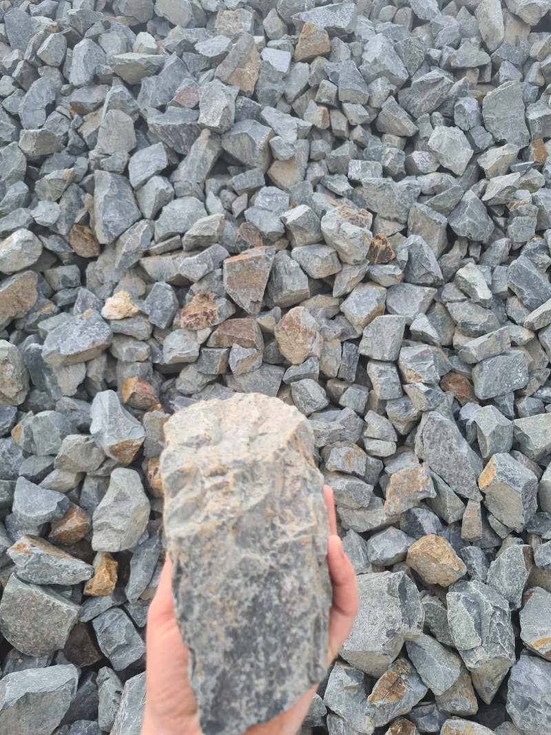 A Person Is Holding A Piece Of Big Rock — Campbell's Truck and Bobcat and Landscape Supplies In Gympie, QLD